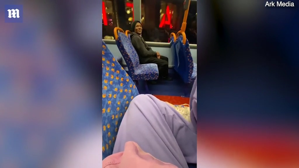 Creepy smiling Black man stares at White woman on London bus
